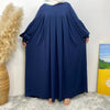 Ein langes marineblaues, elegantes islamisches Kleid für Damen vor einer weißen Wand.