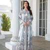 Une femme modélise une élégante longue abaya perlée en diamant, à motifs floraux bleu et blanc, en extérieur.