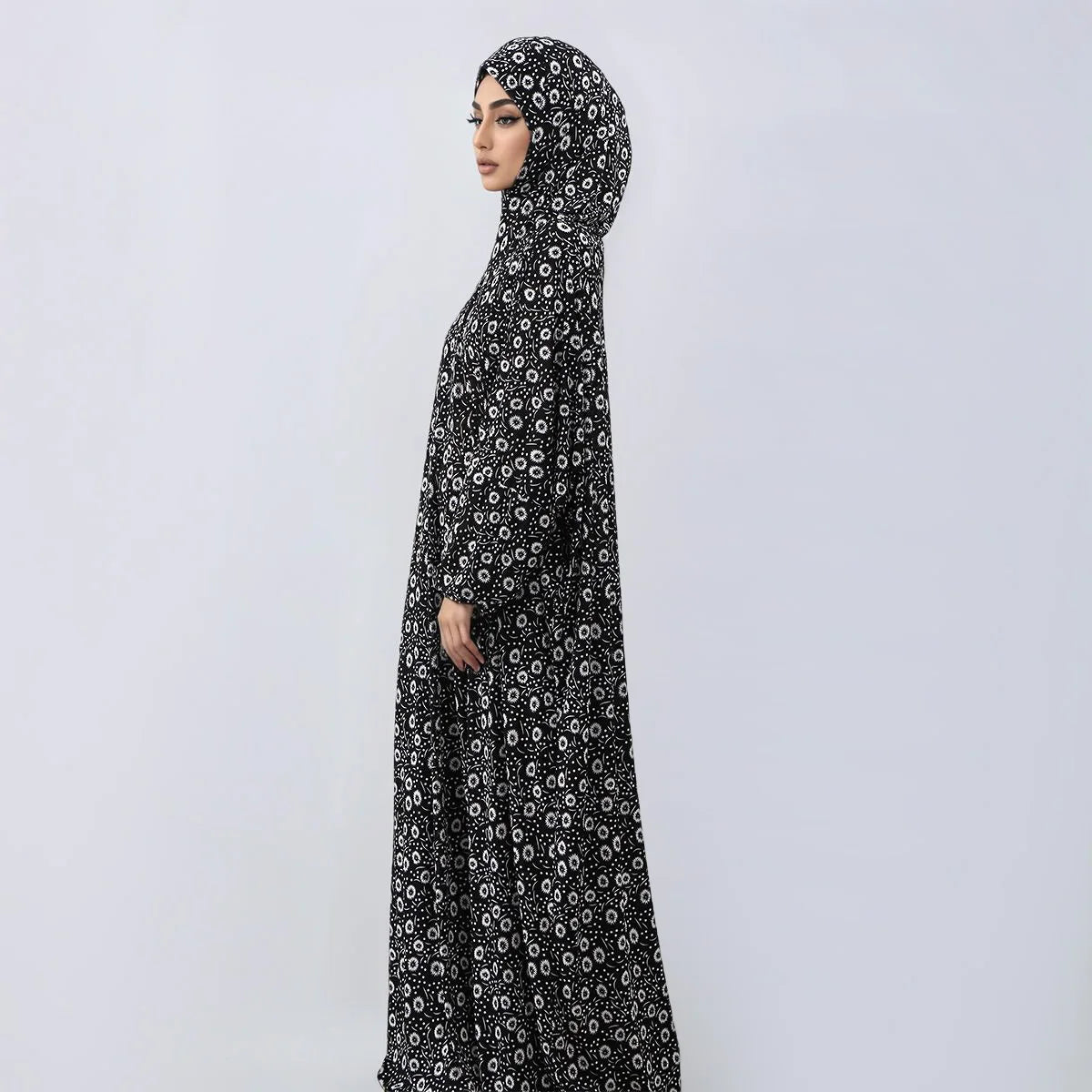 A woman wearing an elegant black patterned hijab dress for prayer and daily wear.