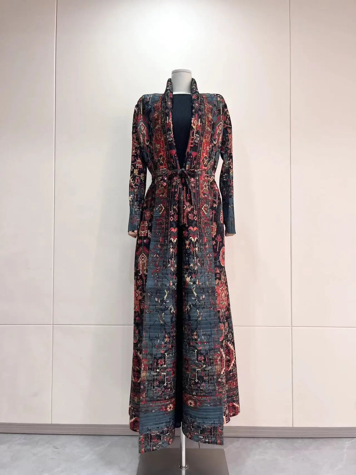 Lange gemusterte Abaya-Cardigan auf einem Mannequin vor hellem Hintergrund.