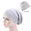 Grauer Strickstoff-Beanie-Turbanhut auf einem Mannequin mit Detailansicht der Satinfutter.