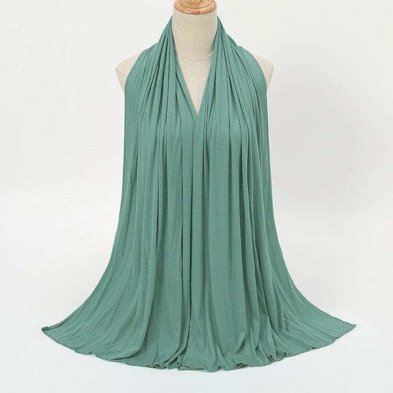 A teal soft modal jersey hijab scarf draped around a mannequin's neck.
