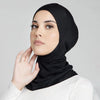Eine Frau trägt eine schwarze weiche Modal-Turban-Hijabkappe und passende weiße Kleidung.