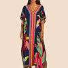 Eine Frau modelliert ein leuchtend farbiges marokkanisches Batwing Kaftan-Überkleid mit V-Ausschnitt und weiten Ärmeln.