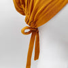 Pañuelo elegante turbante modal amarillo mostaza atado con un lazo de tela.