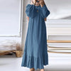 Une femme portant une longue robe maxi bohème bleue à manches et à ourlet froncés.