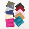 A collection of solid color silk satin hijab scarves in shades of olive green, gray, black, maroon, pink, and teal.