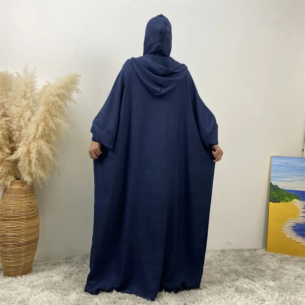 Une abaya bleu foncé avec capuche et manches batwing, présentée sur fond blanc.