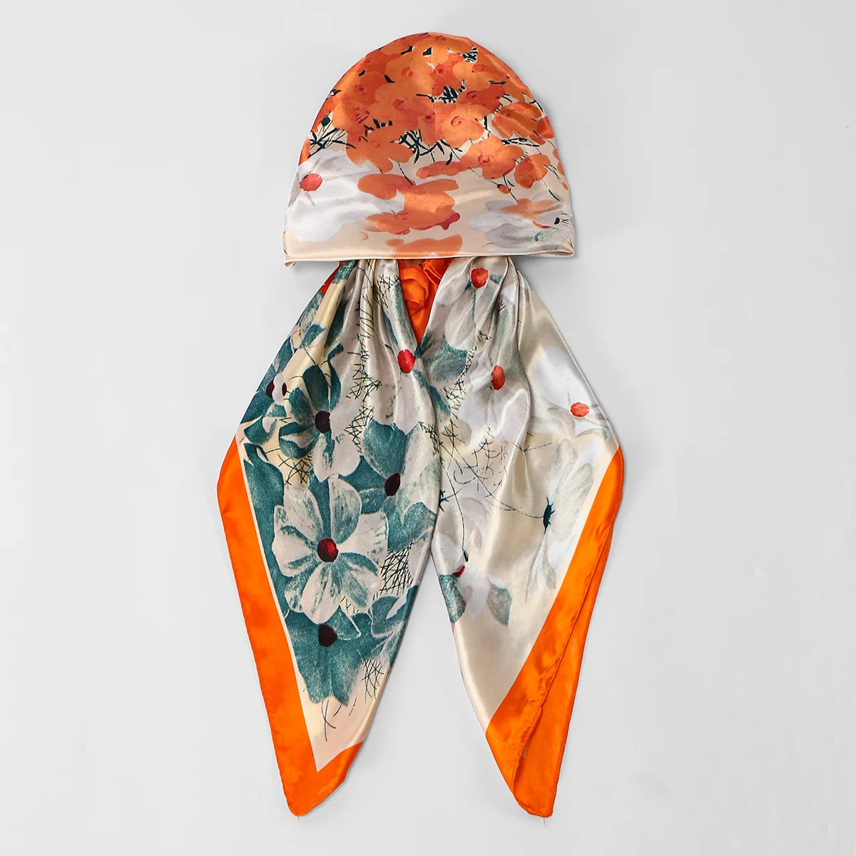 An elegant satin silk instant hijab scarf featuring an orange floral print and a teal botanical pattern.