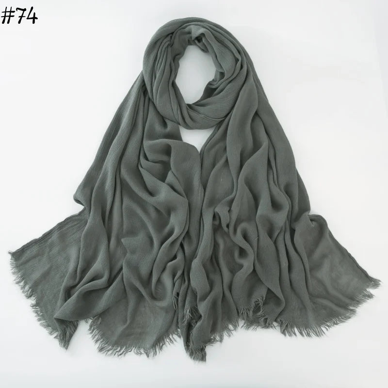 Foulard hijab en coton viscose gris drapé et plié sur fond blanc.