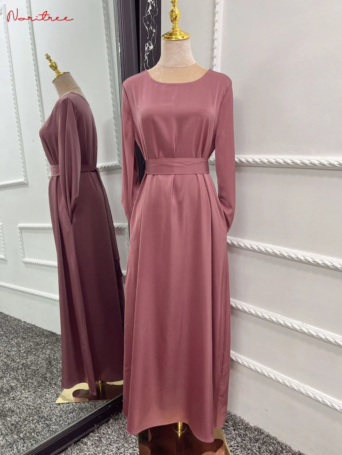 Mauve, langes Abaya-Kleid mit Gürtel und langen Ärmeln auf einem Mannequin.