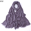 Foulard hijab en coton viscose gris doux, drapé et plié, avec des bords effilés.