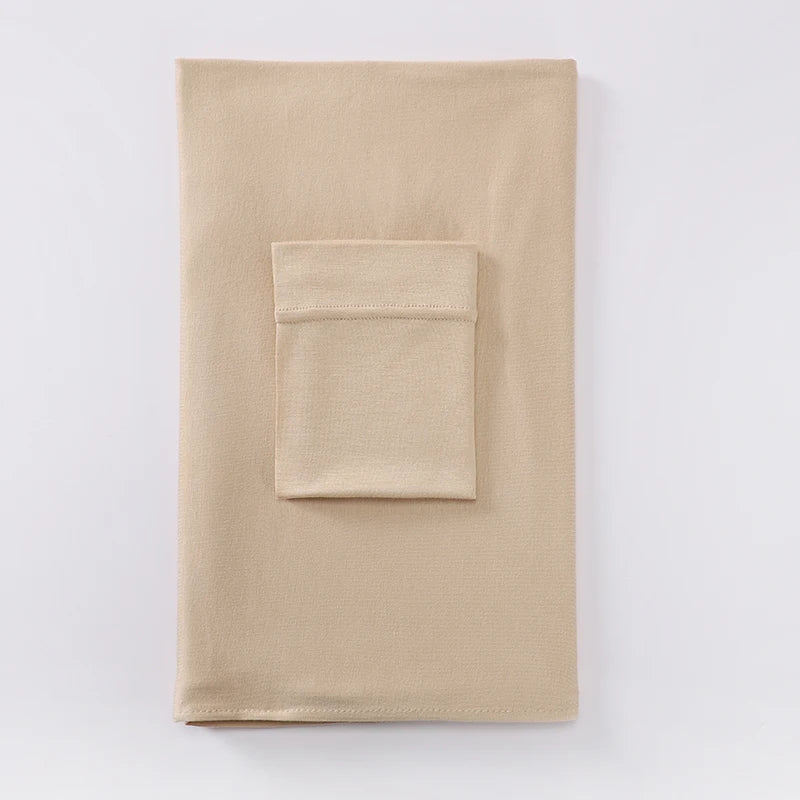 Un conjunto de hijab de dos piezas a juego de jersey beige, mostrado plano contra un fondo blanco.