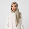 Une femme portant un foulard triangle élégant beige et un haut blanc.