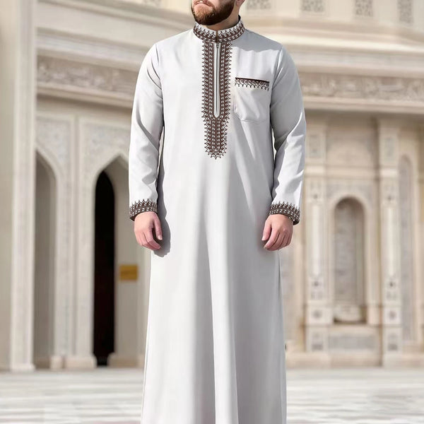 A man wearing a light gray Moroccan ethnic thobe with a stand collar and decorative embroidery.