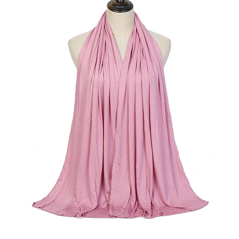 A pink soft modal jersey hijab scarf draped around a mannequin's neck.