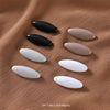 Set of 8 black and grey solid color brooch pins arranged on a brown fabric background