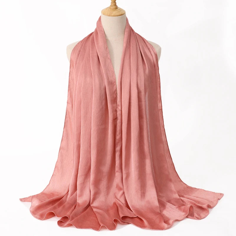 Fließender, staubrosa Satin-Crinkle-Hijab-Schal auf einem Mannequin.