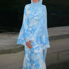 Eine Frau trägt ein hellblau-weißes Blumenmuster-Abaya oder Kaftan mit gerafften Ärmeln.