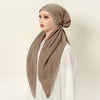 Modelo usando una diadema de elástico de diamantes beige para hijab, estilizada con una prenda blanca.