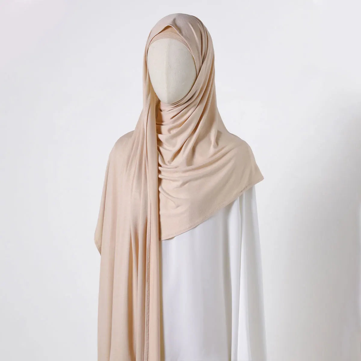 Beige Chiffonschal über einem Mannequin, der einen eleganten einfarbigen Schal zeigt.