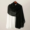 Pañuelo de hijab modal negro de rayón drapeado sobre una prenda blanca.