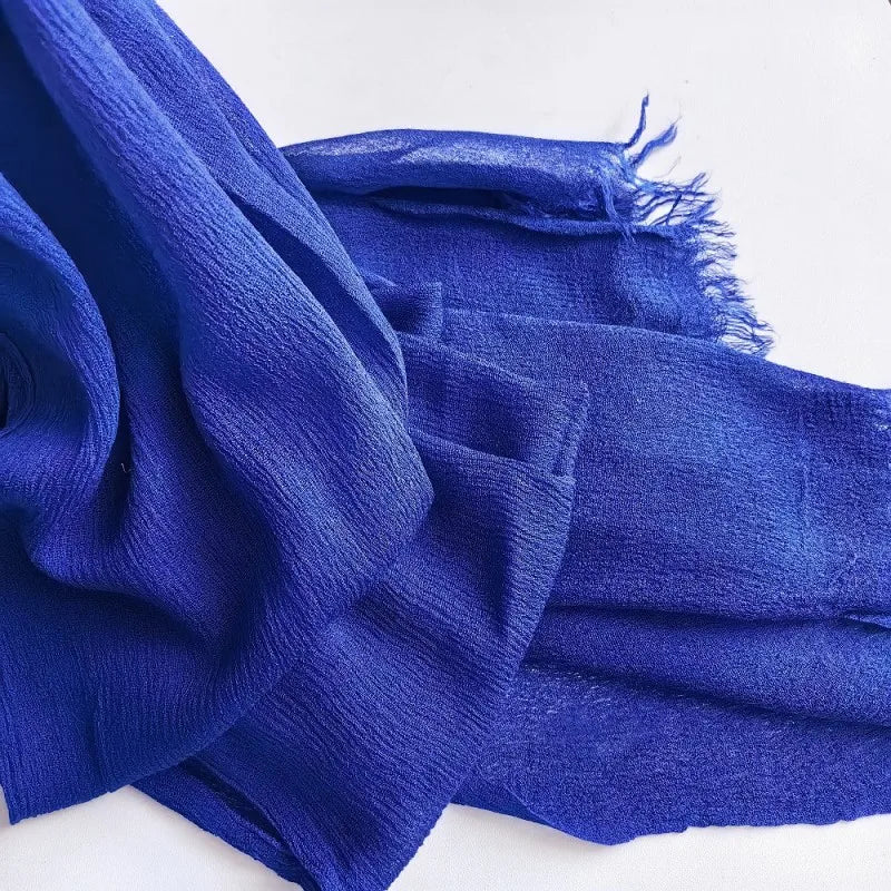 Écharpe hijab en coton viscose bleu profond avec pompon sur fond blanc.
