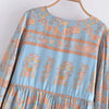 A light blue bohemian floral maxi dress featuring intricate orange and pink patterns and lantern sleeves.