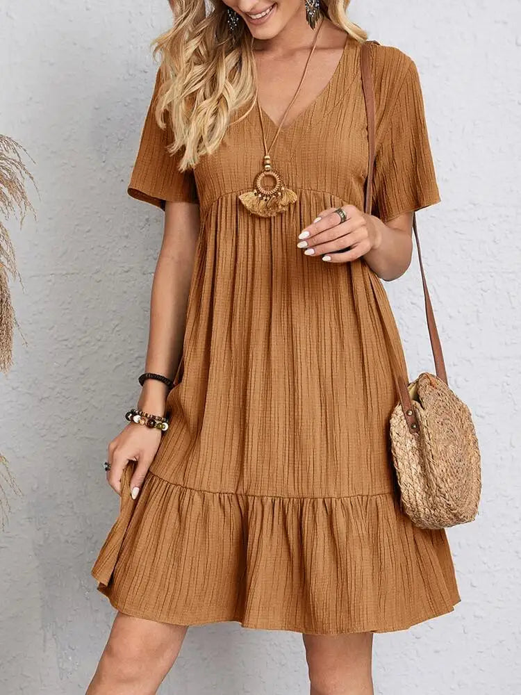 Eine Frau trägt ein elegantes, einfarbiges braunes V-Ausschnitt-Kleid im A-Linien-Mini-Stil mit kurzen Ärmeln und einer geflo