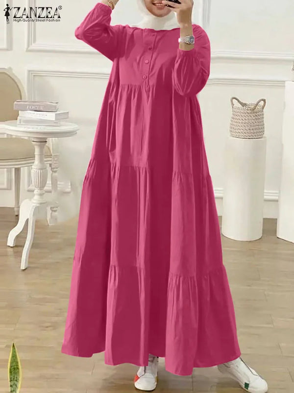 A woman wearing a long, pink Muslim abaya kaftan dress with a high neckline and gathered fabric.