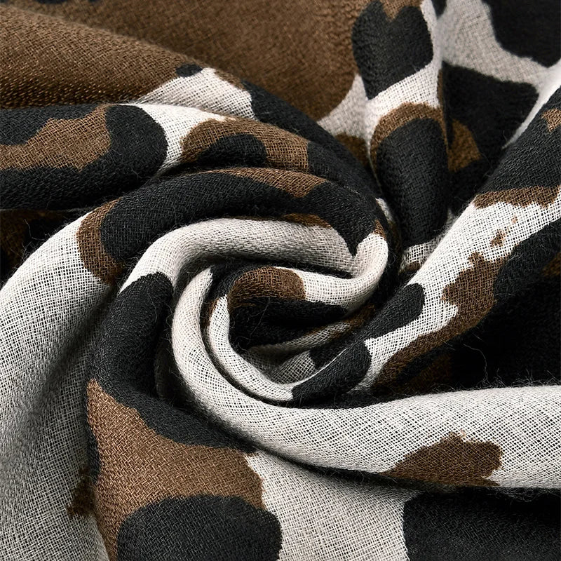 Gros plan sur un tissu à imprimé léopard marron, noir et crème, enroulé en spirale.