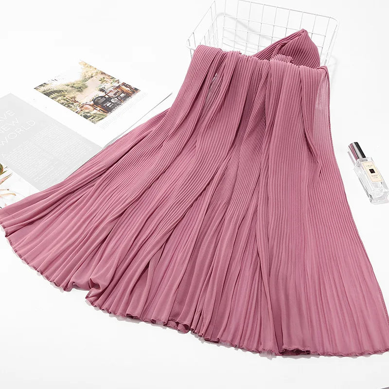Fließender, staubrosa Crinkle-Chiffon-Hijab-Schal auf weißem Untergrund.