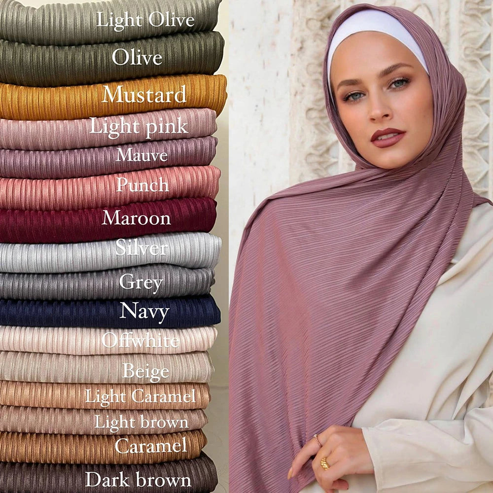 Primer plano de una mujer usando un pañuelo tipo hijab de jersey de algodón en tono malva y rosa suave.