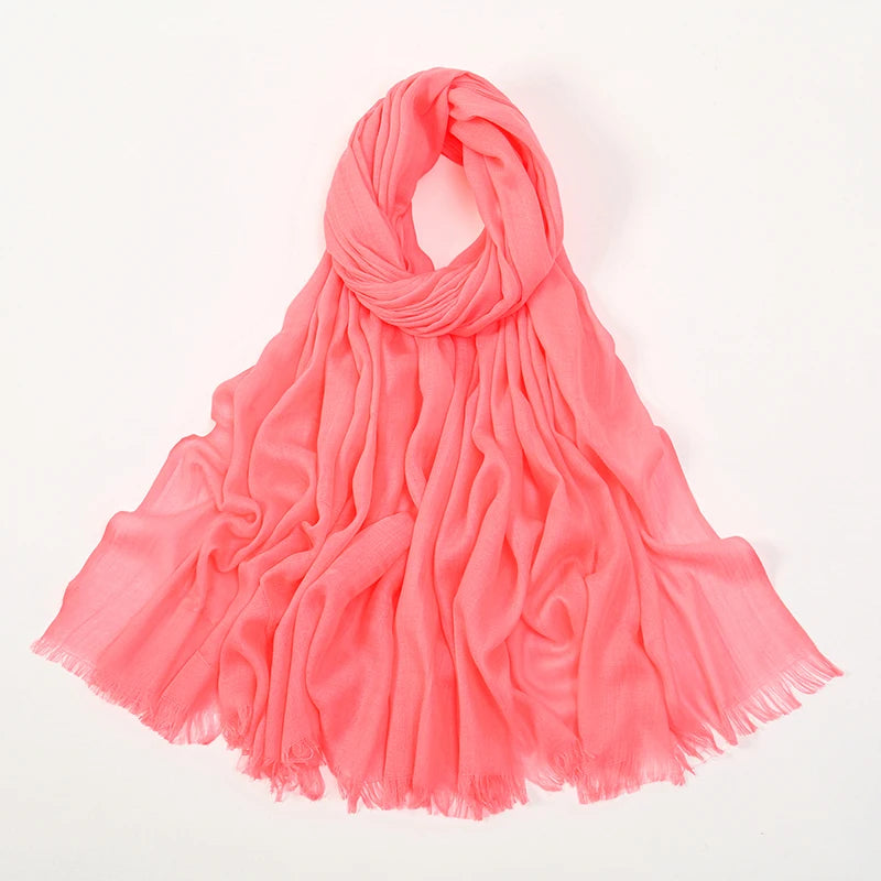 Pañuelo de hijab de bambú coral rosa fluida, drapeado y doblado sobre fondo blanco.
