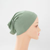 Helle salbeigrüne Bambus-Jersey-Turbanmütze auf einem Mannequin.