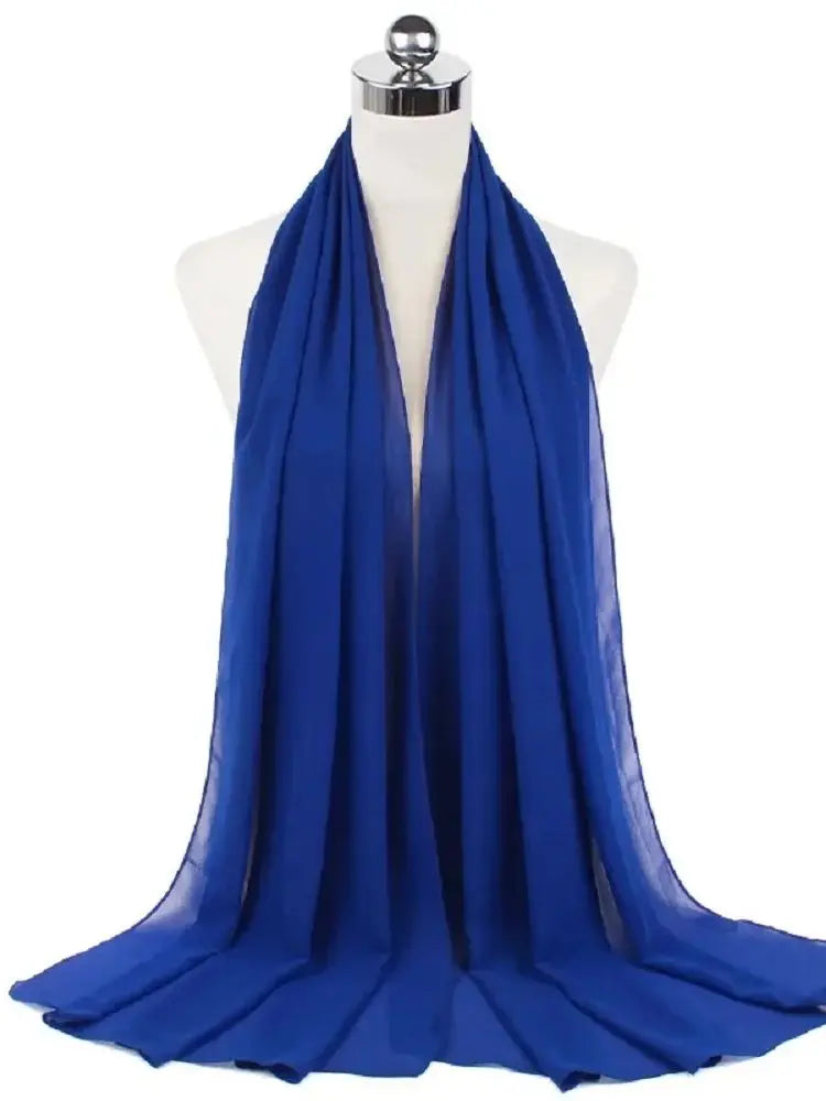 Ein königsblaues Chiffon-Hijab-Schal, um den Hals einer Mannequin drapiert.