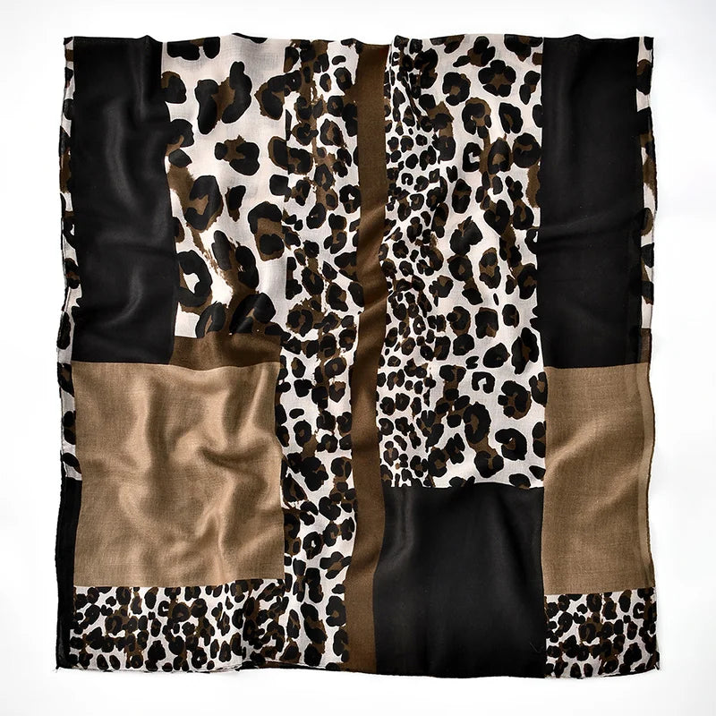 Un châle ou hijab rectangulaire à imprimé léopard noir et blanc avec des panneaux noirs et marrons unis.