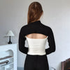 Eine Frau trägt ein schwarzes Langarm-Top mit einem weißen Crop-Shirt, von hinten gezeigt.