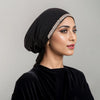 Eine Frau trägt einen schwarzen Samt-Hijab mit einem funkelnden Strass-Detail auf der Stirn.