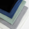 Ein Stapel eleganter Chiffon-Schals in Schwarz, Marineblau, Salbeigrün und Grau.