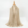 A beige chiffon hijab shawl with delicate floral embroidery displayed on a mannequin.
