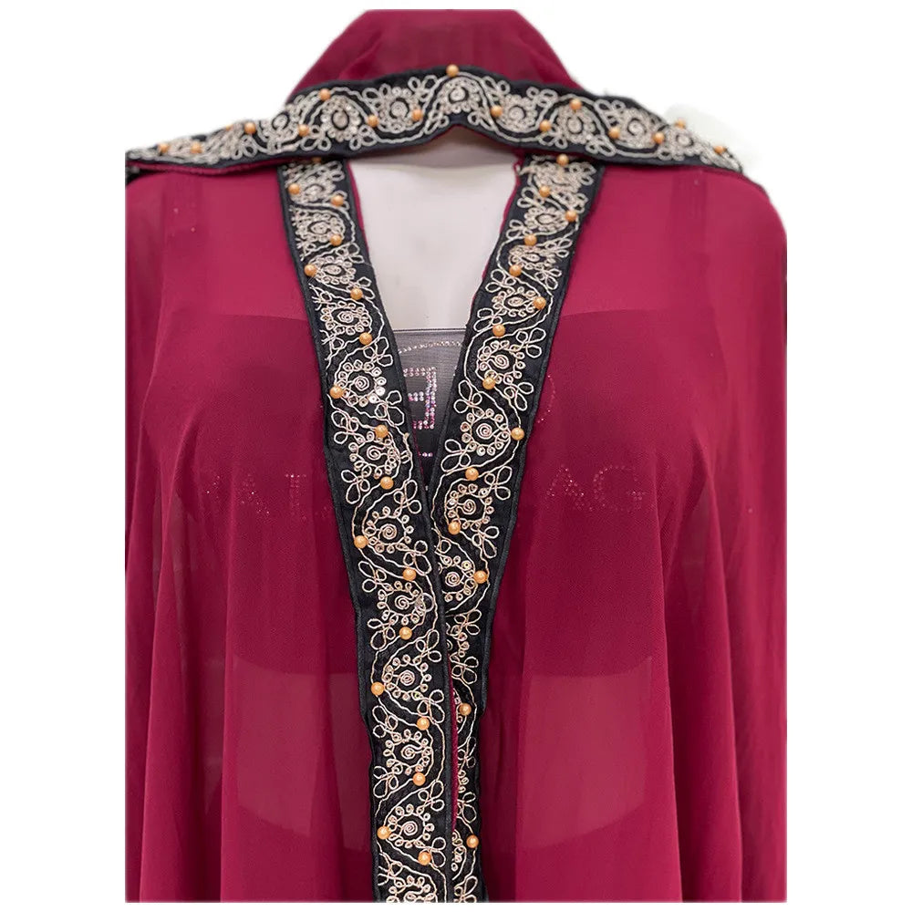Vestido largo abaya fluido color granate con mangas tipo ala y bordado negro y dorado intrincado.