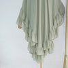 A flowing, light sage green chiffon hijab featuring ruffled layers and a draped design.