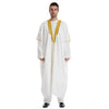 Mann in weißer Jubba-Thobe-Kaftan mit goldenen Verzierungen und schwarzen Schuhen