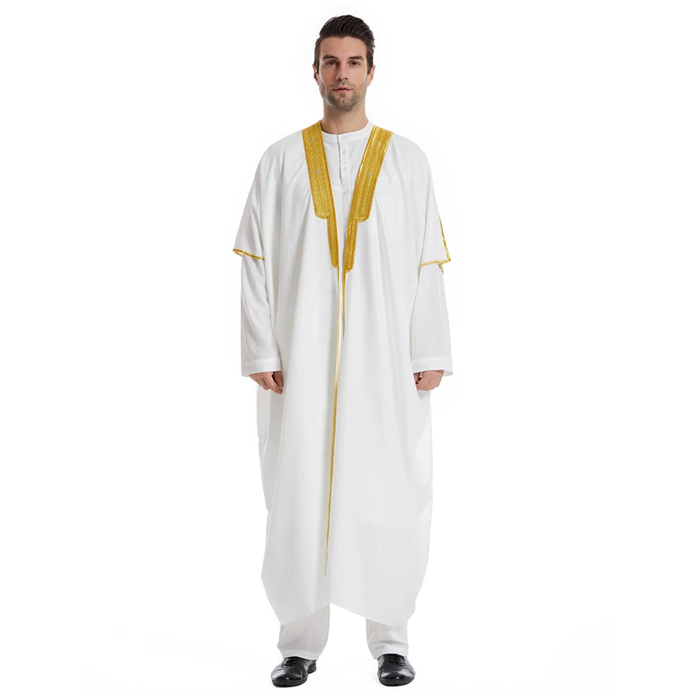 Mann in weißer Jubba-Thobe-Kaftan mit goldenen Verzierungen und schwarzen Schuhen