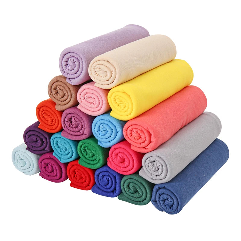 Ein Stapel gerollter Damen-Baumwoll-Jersey-Hijab-Schals in verschiedenen Pastell- und leuchtenden Farben.