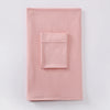 Un conjunto de dos piezas de hijab a juego en jersey color rosa empolvado suave, mostrado plano sobre una superficie blanca.
