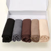 Ein Set von fünf einfarbigen Jersey-Hijab-Schals in Schwarz, Grau, Braun, Beige und Creme in einer weißen Box.