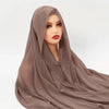 Eine Frau trägt einen fließenden, durchscheinenden taupefarbenen Chiffon-Hijab mit einer Kappe.