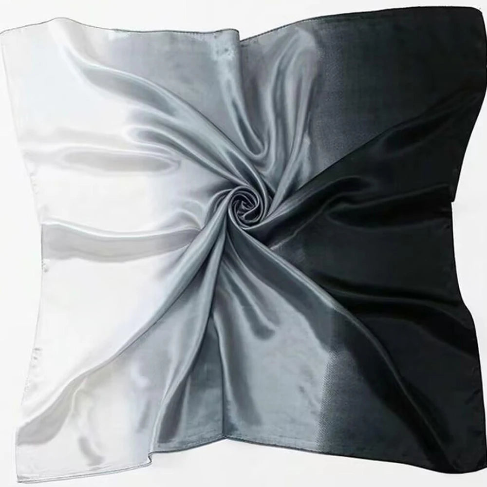Étoffe soyeuse d'un foulard présentant une transition de gradient du blanc au noir.